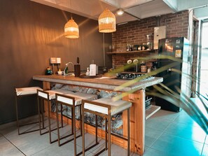 Eine Küche mit Bar, Holzstühlen und hängenden Pendelleuchten.