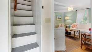 Eine Treppe führt zu einem Wohnbereich mit einer Couch, einem Tisch und einer Lampe.
