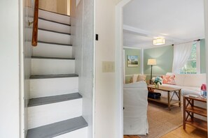 A staircase leading to a living area with a sofa, a table, and a lamp. - Spacious pet-friendly home, close to Nauset & Skaket beaches and Orleans village (Orleans)