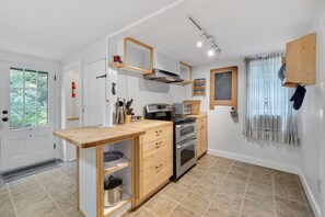 A compact kitchen with a central island, built-in oven, and a small dining area. - Spacious pet-friendly home, close to Nauset & Skaket beaches and Orleans village (Orleans)