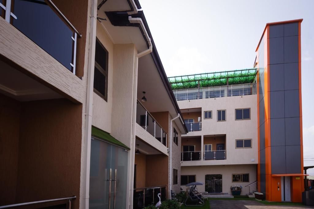 A multi-story building with balconies, a covered outdoor area, and a separate orange structure.