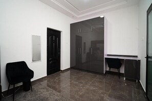 A room with a black door, a glass cabinet, a desk, and a chair. - Cherry Signature Condos (Adenta Municipality)