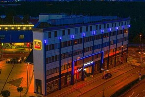 A multi-story hotel with a prominent 'Hotel' sign, a visible entrance, and a parking lot. - Hotel Rhein-ruhr (Bottrop)