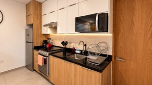 Une cuisine moderne équipée d’une cuisinière, d’un évier et d’un four à micro-ondes.