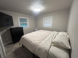 A bedroom with a bed, a dresser, two windows with blinds, and a ceiling light. - Notre Dame stadium 17 mins. Sleeps 6 “ 5 star host” (South Bend)