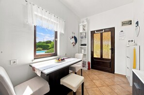 Eine kleine Küche mit Fenster, Tisch und einer Bank.