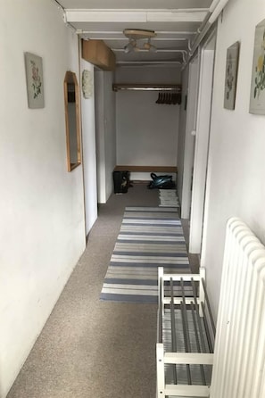 A narrow hallway with a striped rug, a radiator, and a bench. - Chalet Waldesruh (3 ZWhg.) Appartement/Fewo, Badewanne, Komfort 4-Bettwohnung by Interhome (Arosa)