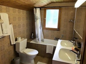 Une petite salle de bain comprenant des toilettes, un lavabo et un espace douche.