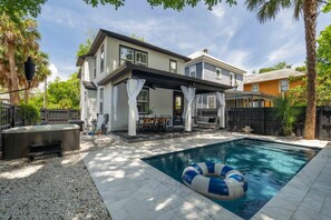 A two-story house with a covered patio and a swimming pool. - The Slate Retreat | Pool + Hot Tub (Jacksonville)