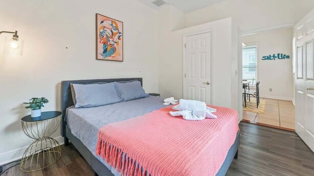A bedroom with a bed, bedside table, and a painting on the wall. - Historic Gem in Springfield - Grill, Private Deck (Jacksonville)