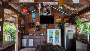 Une cuisine rustique avec des meubles en bois, un coin bar et un téléviseur fixé au mur.