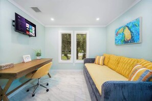 A room with a bed, a desk, a chair, a TV, and a window. - "Sea Grape Villa" Pool/ Ping Pong, (Jacksonville Beach)