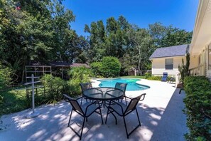 A backyard with a swimming pool, a covered patio, and a house. - Coastal Lane - Entire (Jacksonville)