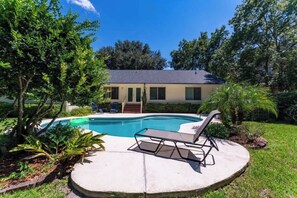 A residential property with a swimming pool, a covered patio, and a house with a dark roof. - Coastal Lane - Entire (Jacksonville)