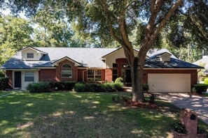 A two-story house with a garage, a front yard, and a tree. - Coastal Lane - Entire (Jacksonville)