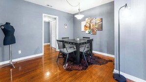 Un espace repas comprenant une table ronde, des chaises, un mannequin et un lampadaire.