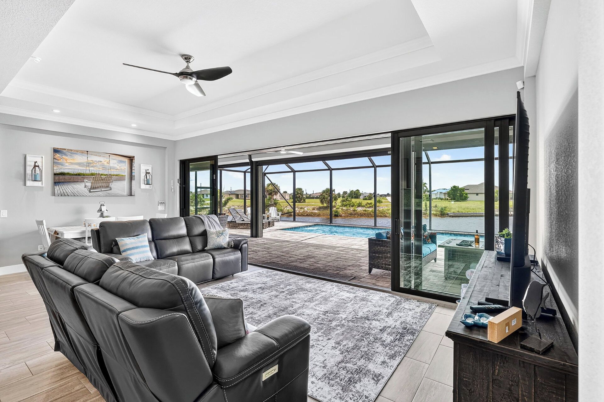 A spacious living area with a pool, a ceiling fan, and a view of the outdoors.