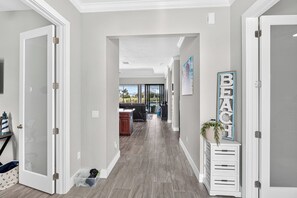 A hallway with a view to a living area, a white cabinet with drawers, and a wall-mounted sign. - VRCC Villa Penny River (Cape Coral)