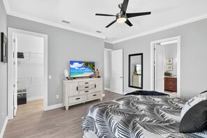 Ein Schlafzimmer mit einem Bett, einem Fernseher, einem Deckenventilator und einem Kleiderschrank.