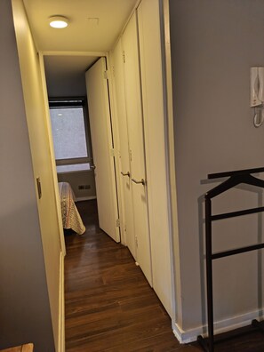 Ein Flur mit Holzboden, weißen Türen und einem Telefon an der Wand.