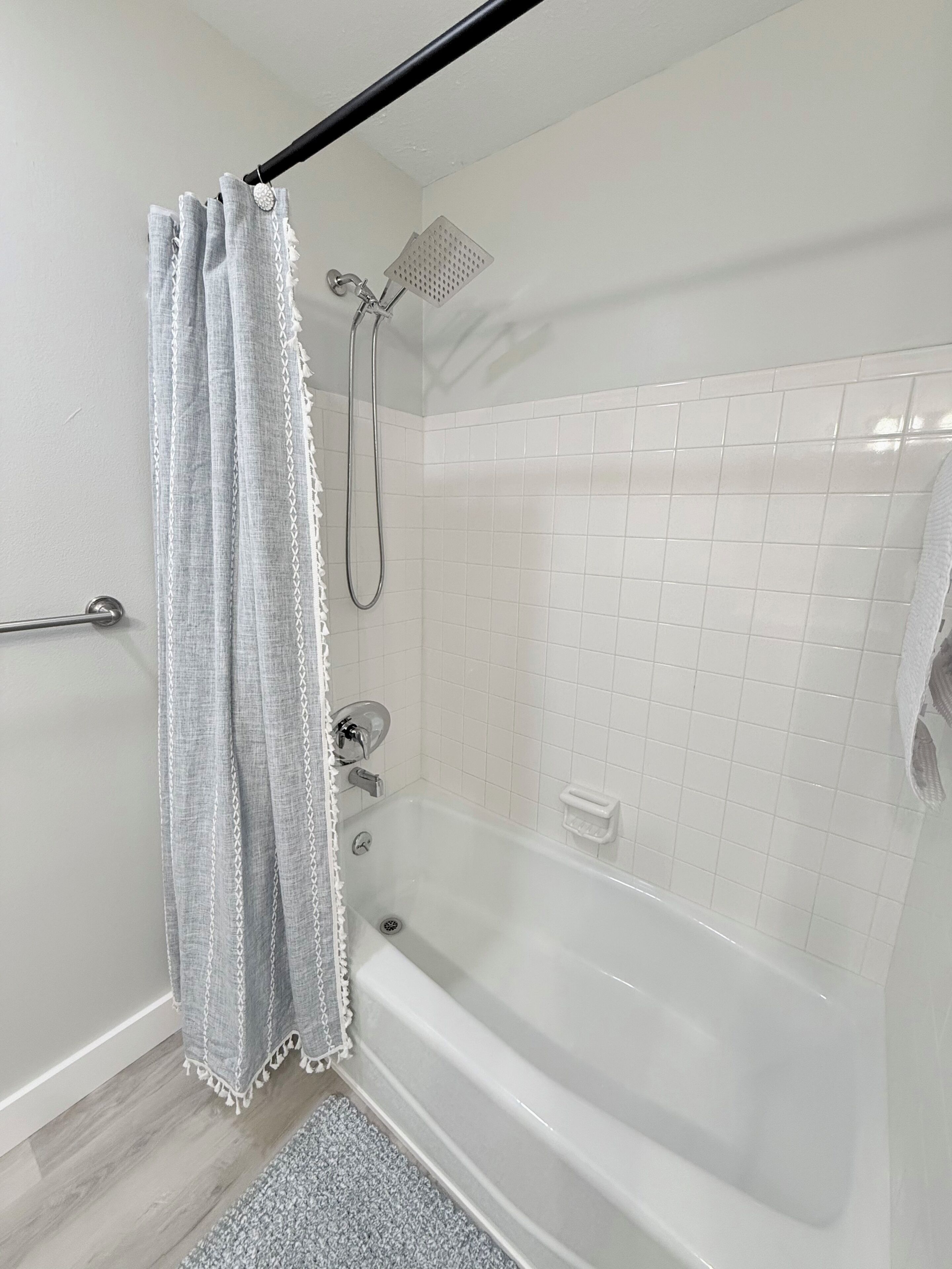 Ein Badezimmer mit Badewanne, Dusche und Handtuchhalter.