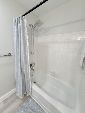 Ein Badezimmer mit Badewanne, Dusche und Handtuchhalter.
