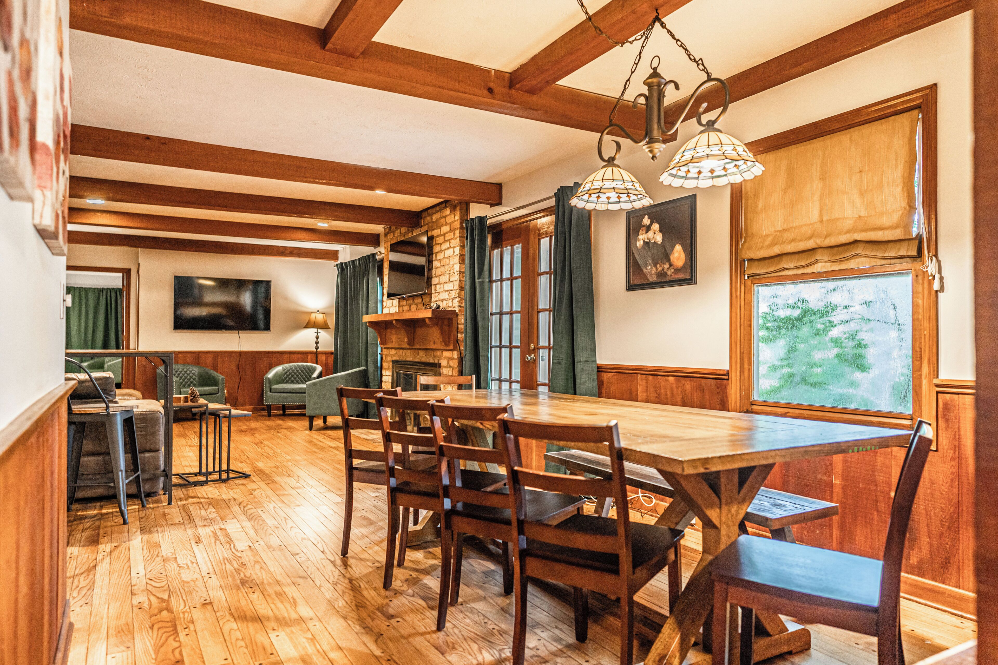 A dining area with wooden furniture, a fireplace, and a large window with a view.