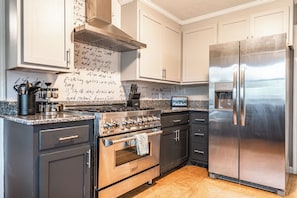 Eine moderne Küche mit Edelstahlgeräten, einem Gasherd und einem Kühlschrank.