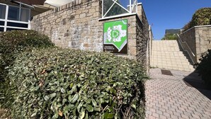 Eine Steinmauer mit einem grünen Schild, das ein Wohngebiet kennzeichnet.