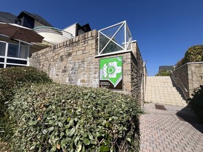 A stone wall with a green sign indicating a residential area. - Cat Oceania 2 - CARNAC (CARNAC)