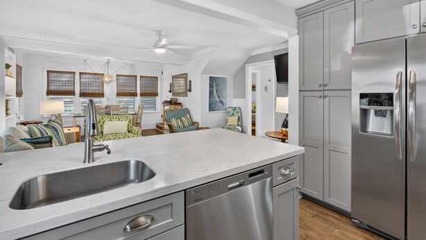 A modern kitchen with a built-in dishwasher, stainless steel appliances, and a large island with a sink. - Downtown Rehoboth Beach House Quick Walk to Beach Pets Permitted (Rehoboth Beach)