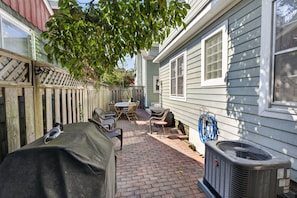 A patio with a grill, outdoor furniture, and a brick pathway leading to a house. - Downtown Rehoboth Beach House Quick Walk to Beach Pets Permitted (Rehoboth Beach)