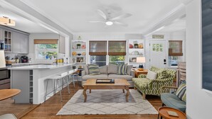 A modern kitchen with white cabinets, a bar area, and a dining space. - Downtown Rehoboth Beach House Quick Walk to Beach Pets Permitted (Rehoboth Beach)