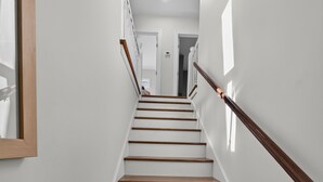 A staircase with wooden steps and a wooden handrail, leading to a door at the top. - Downtown Rehoboth Beach House Quick Walk to Beach Pets Permitted (Rehoboth Beach)