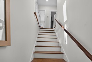 Eine Treppe mit Holzboden und einem Holengeländer, die zu einer Tür führt.