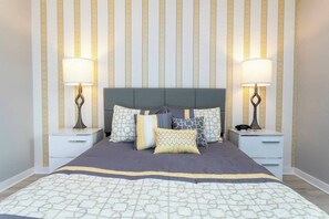 A neatly made bed with a patterned bedspread, two bedside lamps, and a headboard. - Private Pool | No Carpet | Walk to Walmart | Spotless (Kissimmee)