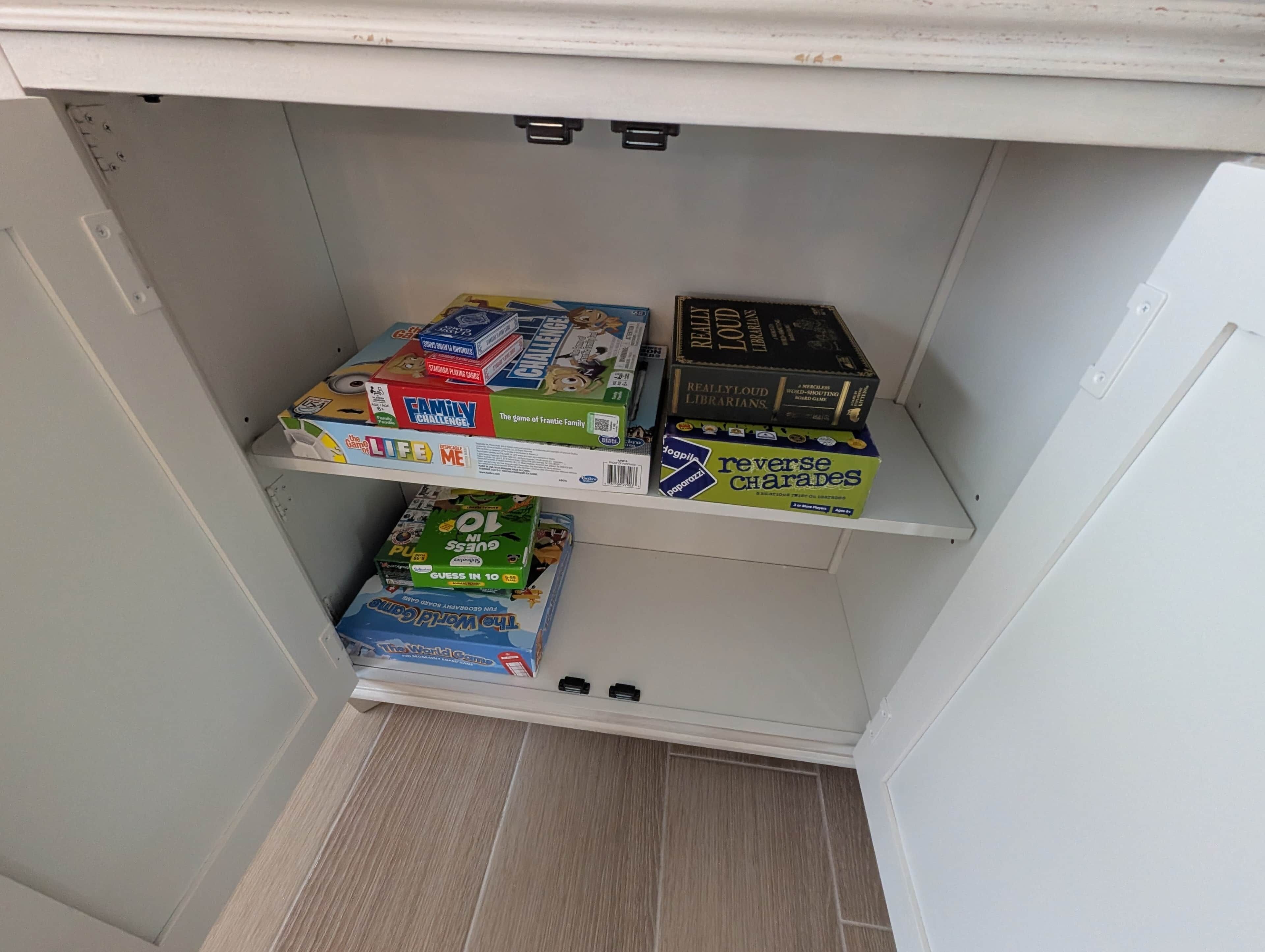 A shelf with various board games, including 'Family Challenge' and 'Guess in 10'.