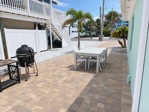 A patio with a grill, a table, and chairs. - Sea Glass Retreat (Manasota Key)