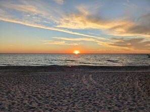 A beach with a sunset over the ocean. - Sea Glass Retreat (Manasota Key)