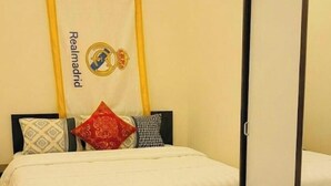 A hotel room with a bed, a mirror, a patterned rug, and a wall hanging with a logo. - Ein Zimmer in 2 Wohnung Zimmer (Vienna)