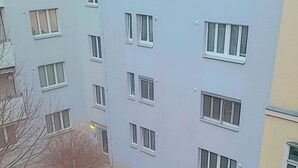 A multi-story building with a flat facade, multiple windows, and a small courtyard with steps leading to the entrance. - Ein Zimmer in 2 Wohnung Zimmer (Vienna)