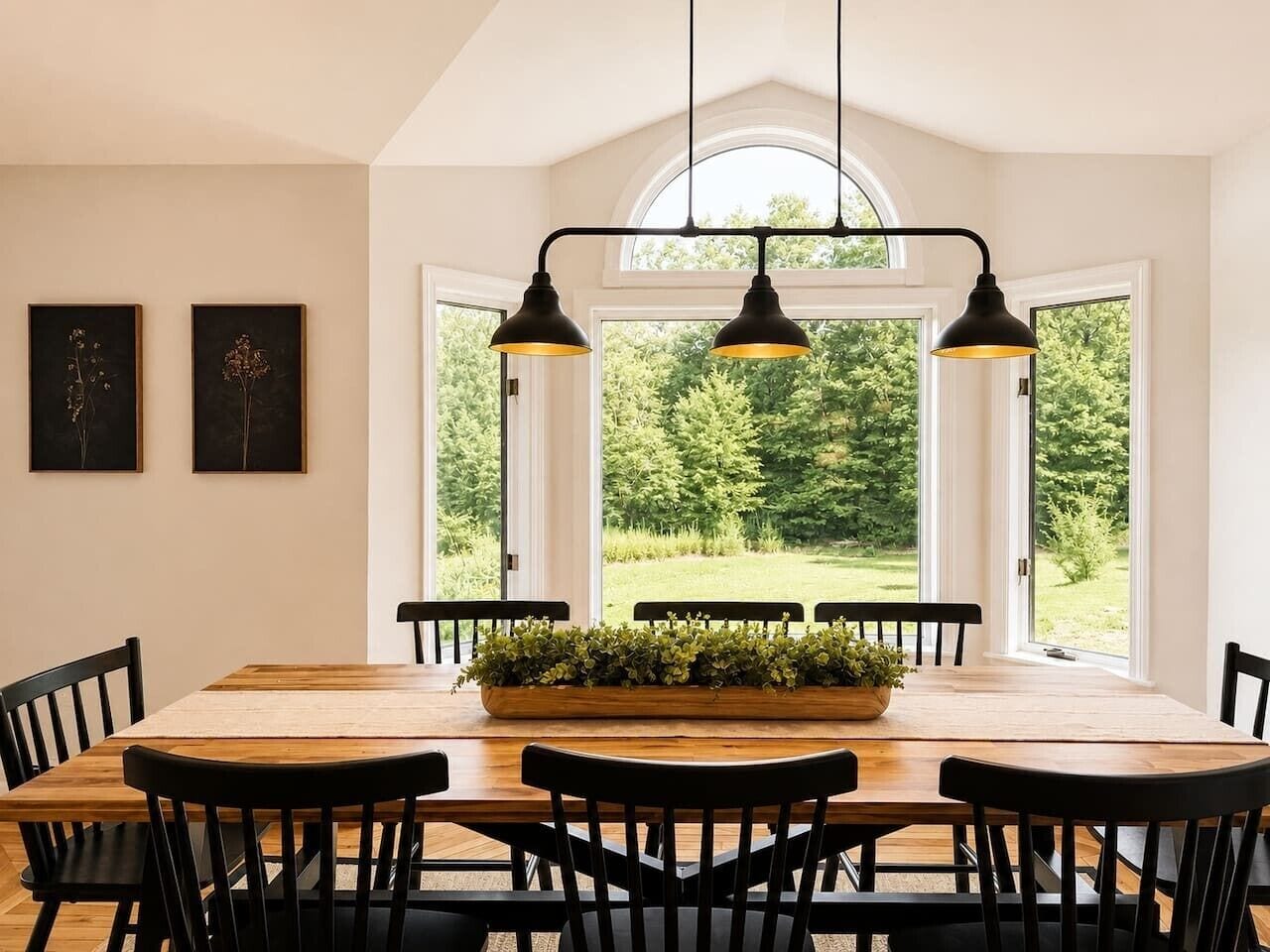 A dining area with a wooden table, black chairs, and a central plant.