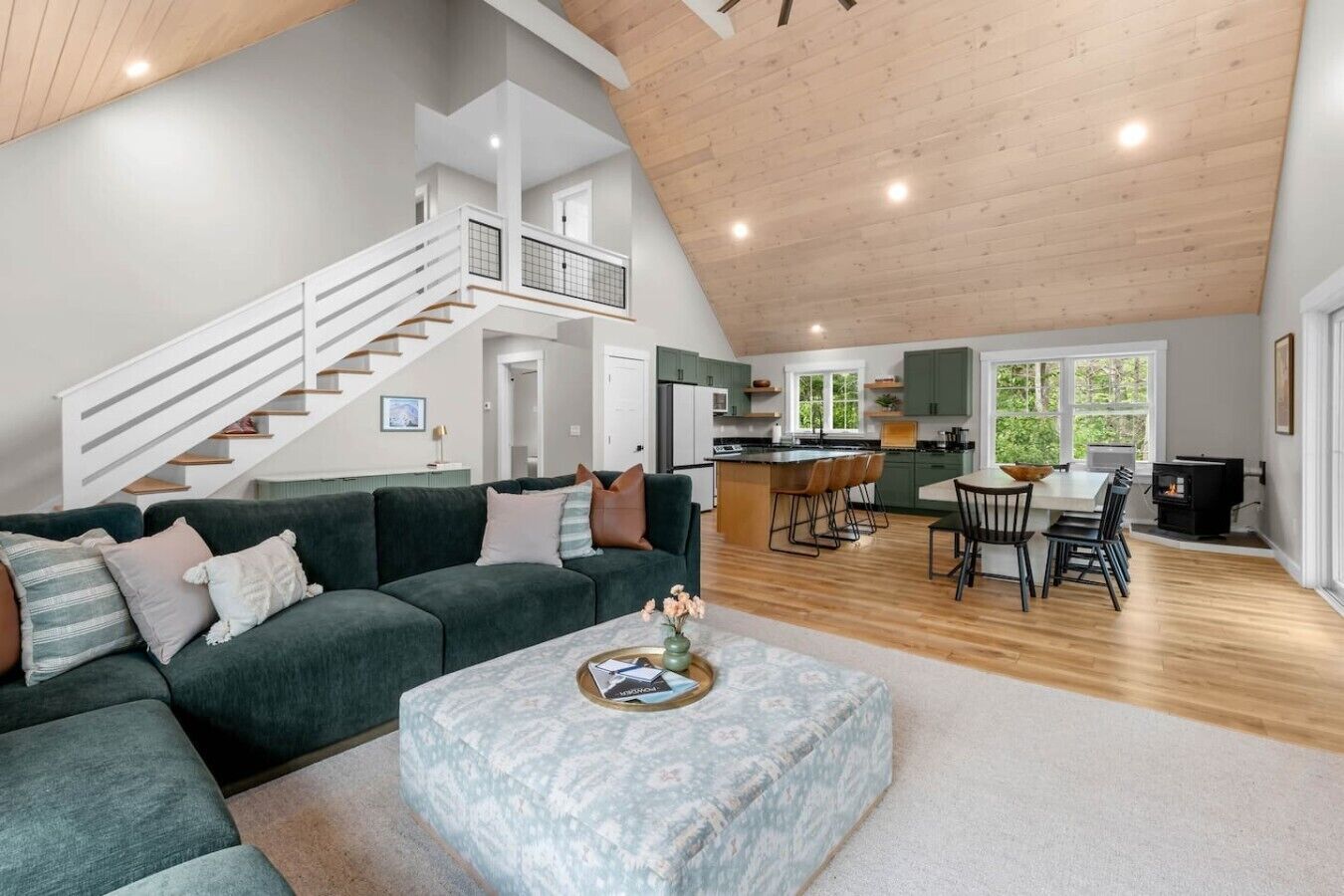 A spacious living area with a staircase, a kitchen, and a dining area.