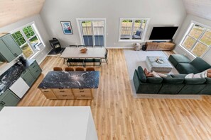 A spacious living area with a dining table, sofa, and kitchen. - Rewind Retreat-King beds, Cinema, Hot tub, Dogs. (Conway)
