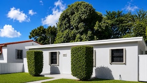 A single-story building with a white exterior, two windows, and a door. - Beautiful & Central Cozy Home (Miami)