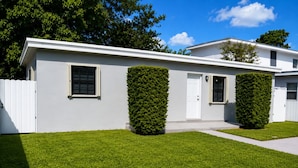 A modern two-story house with a white exterior, a front door, and two windows. - Beautiful & Central Cozy Home (Miami)