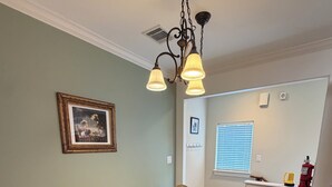 Un'area pranzo con tavolo, sedie e lampadario.