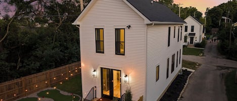A two-story house with a front porch, a visible garage, and a well-maintained lawn.