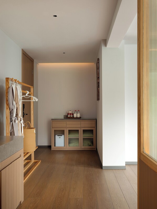 Ein modernes Badezimmer mit einem Holzkosmetikschrank, einem Handtuchhalter und einem Schrank mit Pflegeartikeln.
