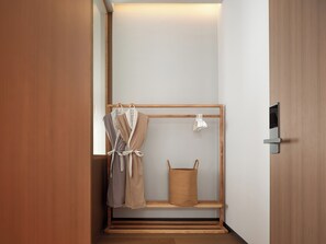A bathroom with a wooden floor, a towel rack, a basket, and a door with a handle. - Zhangjiajie Ruyuan Hotel  (Zhangjiajie)